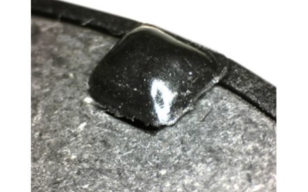 Ein Blech-Stanzteil wird durch einen heißverstemmten Pin in seiner Position fixiert.