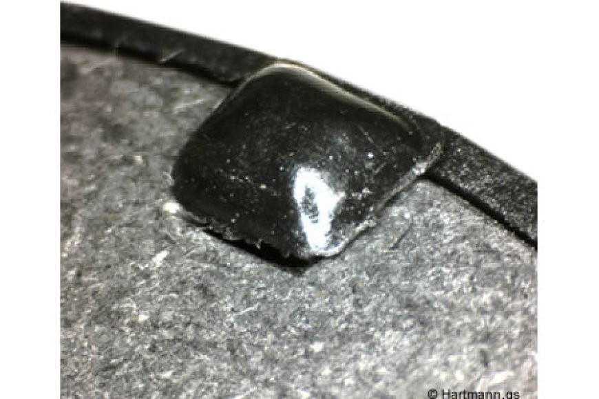 Ein Blech-Stanzteil wird durch einen heißverstemmten Pin in seiner Position fixiert.